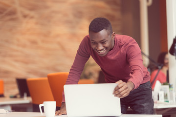 Happy successful African American businessman in a modern startup office indoors