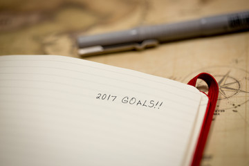 2017 goals notebook and pen on map background top view
