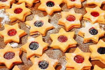 Christmas cookies in the shape of a star sprinkled with sugar on a brown wooden background