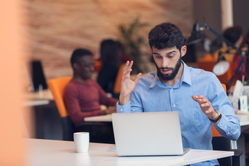 frustrated young business man working on desktop computer