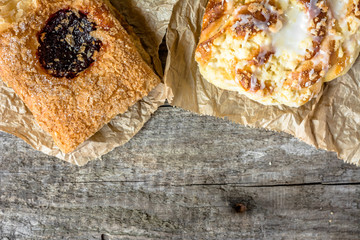 Unhealthy food breakfast - french pastry and sweet bun on wooden table, copy space, flat lay from above