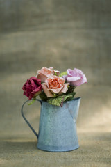 Rose in the pot with blurry hessian texture background, vintage tone filter 