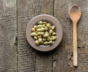 Marinated capers, italian cooking ingredients on wooden table