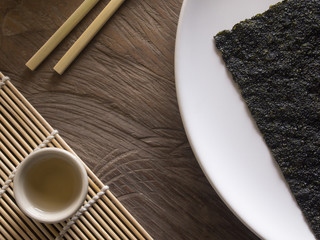 Dry Seaweed on White Dish and tea and Chopsticks on Wood Table