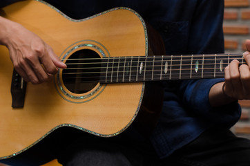 Fototapeta premium .A young man playing acoustic guitar happily in the music room.