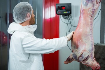 Butcher weighing raw meat