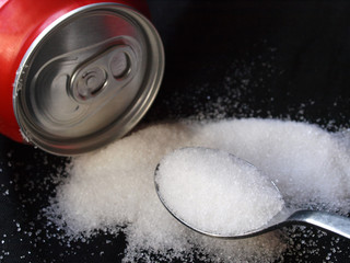 soda can and white sugar spoon