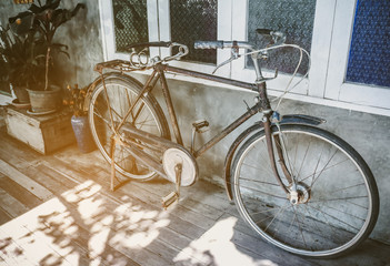Fototapeta na wymiar Old bicycle rusty park at loft wall of house vintage tone.