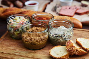 A set of four jars with various combination of salads standing o