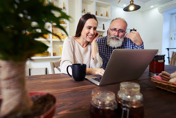 Cheerful Caucasian female works with senior man in a friendly wa