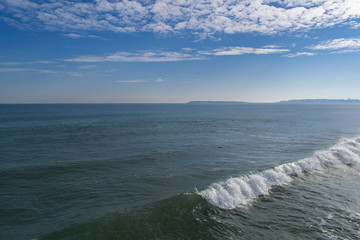 Snowy beach and sea at winter with blue sky