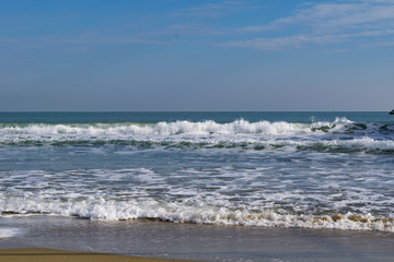 Snowy beach and sea at winter with blue sky