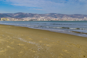 Snowy beach and sea at winter with blue sky