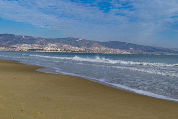 Snowy beach and sea at winter with blue sky