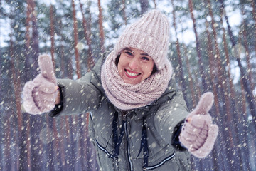 Joyful woman enjoying the winter snow looking at the camera unde