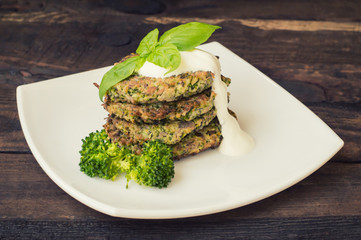 Broccoli and spinach pancakes with yogurt dressing  fresh herbs.