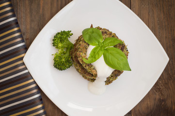 Broccoli and spinach pancakes with yogurt dressing  fresh herbs.