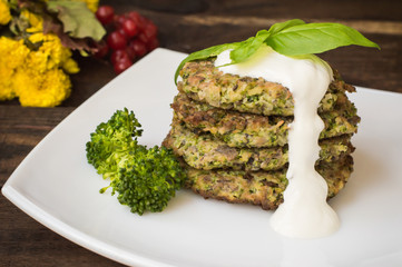 Broccoli and spinach pancakes with yogurt dressing  fresh herbs.