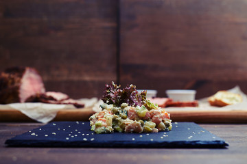 Tasty salad served on a flat plate dressed with sesame and red s