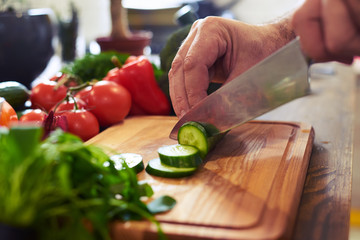 The procedure of slicing cucumber on a cutting board - Powered by Adobe