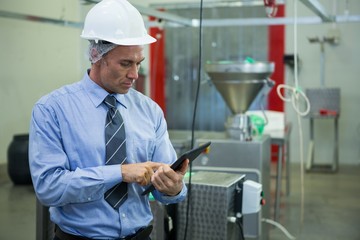 Technician using digital tablet at meat factory