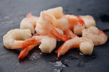 Boiled king shrimps on a black stonge table