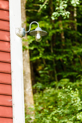 Closeup of lamp on wooden house in forest