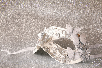 elegant venetian mask on silver glitter background