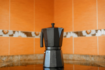 Close-up of black coffee pot on top of a ceramic hob