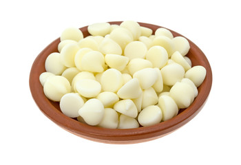 White chocolate baking chips in a small bowl isolated on a white background.