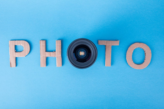 Word PHOTO made from cardboard letters on a blue background made photo from top with lens. High definition.