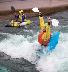 Man playing in a kayak having fun doing stunts in the water.