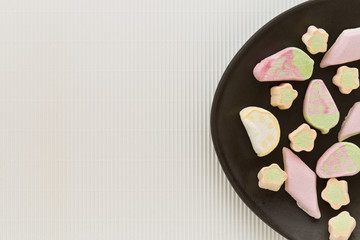 Pastellfarbene bunte Marshmallows auf einem braunen Teller