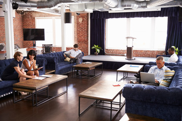 Businesspeople Working In Relaxation Area Of Modern Office