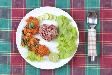 Organic red jasmine rice  with spicy sour fried chicken salad .