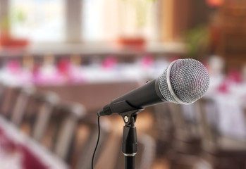Speech or conference concept. Microphone on stand in front of audience.