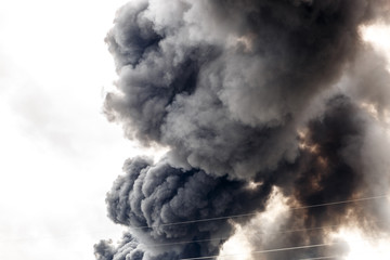 Impressive and thick column of smoke in the middle of the sky