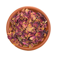 Dried crushed red rosebuds and petals in a small bowl isolated on a white background.