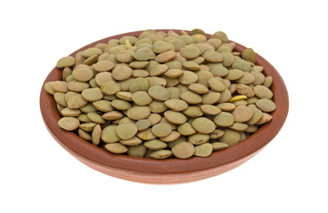 Organic green lentils in a small bowl isolated on a white background.
