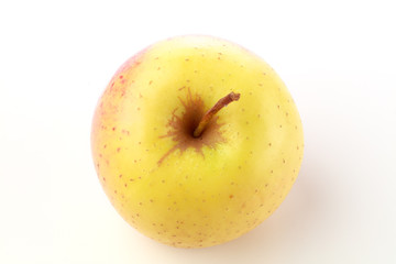 Top view of a yellow apple with stem against a white background