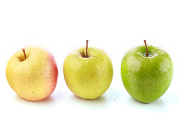 Pink, yellow and a green apple in a row against a white background