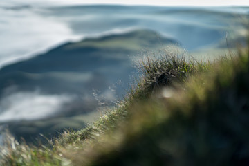 Mountainside grass in sharp focus with a soft-focus background of the great ridge along from Mam Tor, Peak District, Hope Valley on a cold winter morning