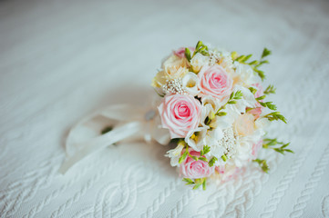 beautiful bridal bouquet of different flowers on a white bed