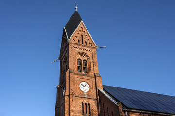 Fototapeta na wymiar Germany, Greifswald, Wieck: Steeple of local neo-Romanesque church (Bugenhagenkirche) of the small fishing village.