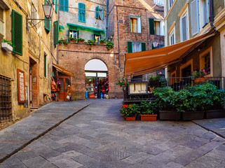 Medieval narrow street in Siena, Tuscany, Italy. Siena is capital of province of Siena. Historic centre of Siena has been declared by UNESCO a World Heritage Site