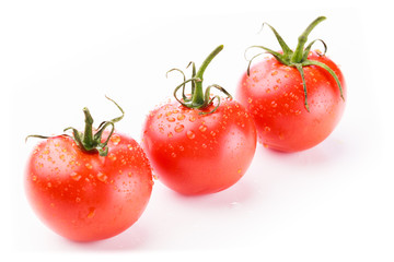 Three fresh red tomatoes in perspective in a diagonal line on a white background