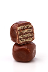 Two square wafer chocolate pieces stacked on a white background