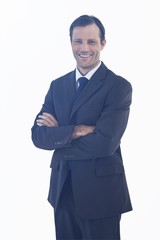 Charismatic smiling businessman standing with arms crossed