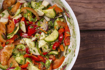 Cucumber and Tomato salad with onion on wooden table
