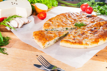 Selective Focus Traditional meat closed pie on the table. Composition of ingridients.